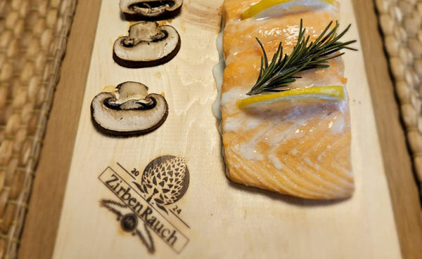 Frischer Lachs auf naturbelassenem Zirbenholzbrett auf dem Grill – aromatisches Grillen mit feinem Holzduft